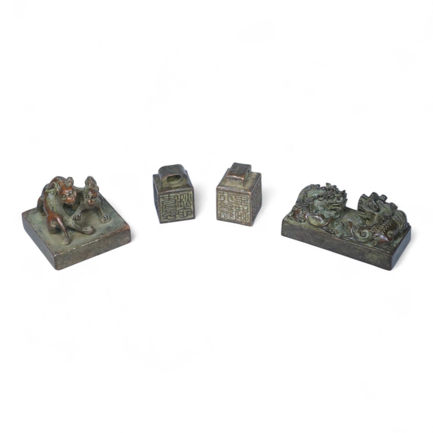 Four Chinese bronze seals, one in the form of two lion dogs, largest 7.5cm wide